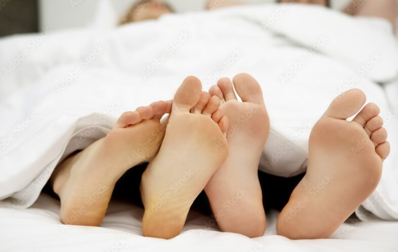 footsies couple feet in bed